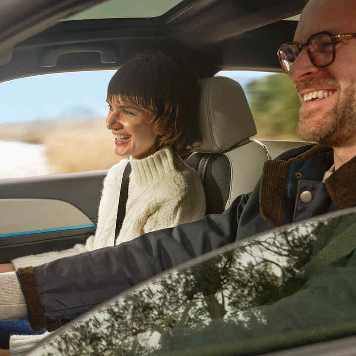 Couple smiling inside of car. 