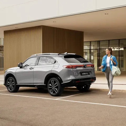 Woman walking alongside a new HR-V.