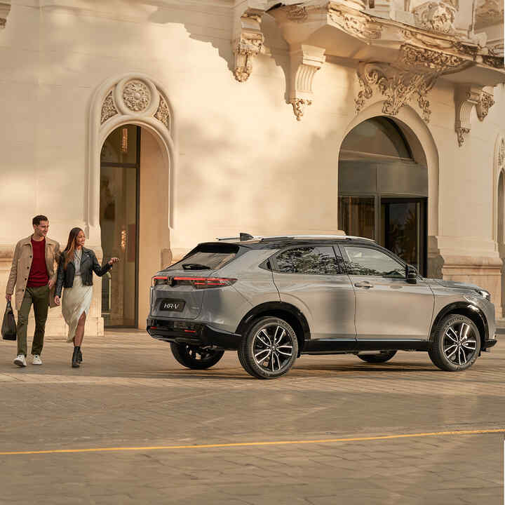 Couple walking next to  HR-V parked outside of building location. 