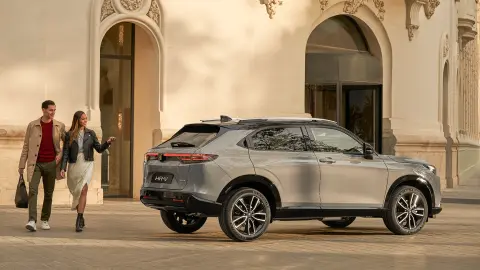 Side facing Honda HR-V outside hotel location, with couple walking by. 