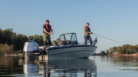 Tow gentlemen fishing off a boat in lake location. 