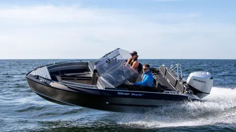 Couple on a silver shark boat using Honda engine. 