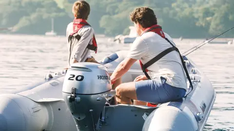 Two males on a Honwave with BF20 engine in lake location.