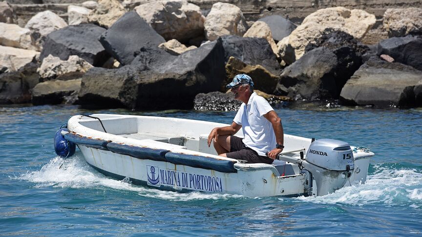 Gentleman on a boat with a BF15 engine in coastal location. 