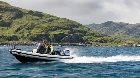 Two gentlemen on boat with Honda engines in lake location. 