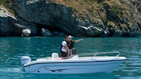 Couple on a small boat in lake location with Honda BF engine.