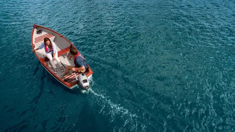 Couple on a boat with Honda engine in water location.