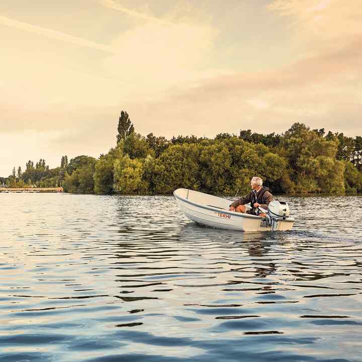 Gentleman on a boat with Honda engine in lake location. 