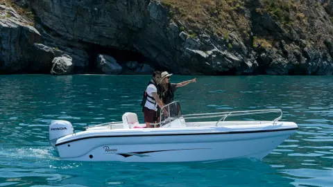 Couple on a boat with Honda BF engine in water location.