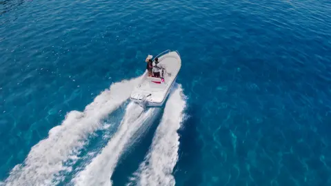 Couple on a boat in the ocean with a Honda BF engine.