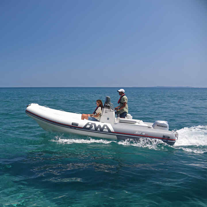 Couple on a side facing boat with Honda BF engine in sea location.