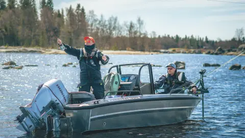 Two gentlemen on boat fishing with Honda BF60 engine in lake location. 