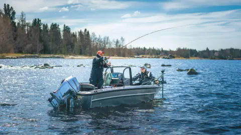 Two gentlemen fishing on a boat  with twin Honda BF60 engines in water location.