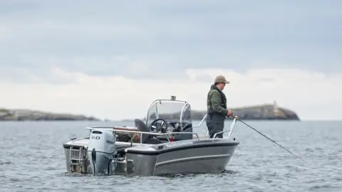 Gentleman fishing on a boat with Honda BF60 engine.