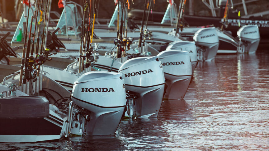 A range of Honda BF60 engines on back of boats in the water. 