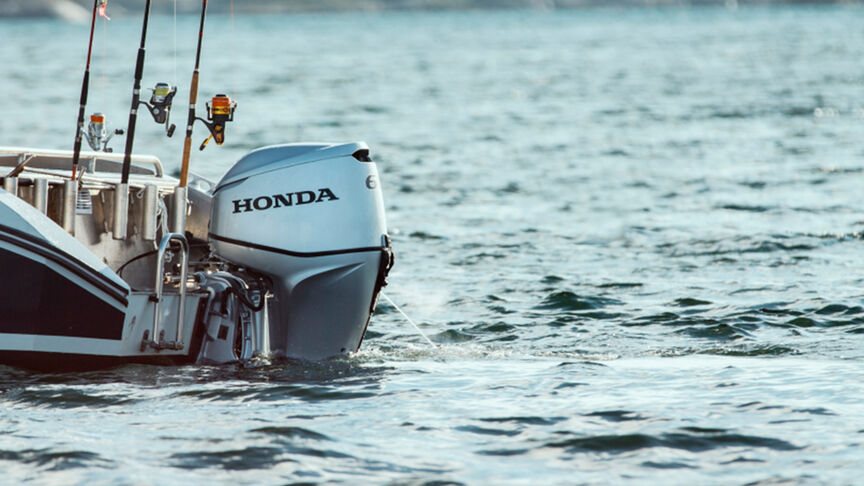 A range of Honda BF60 engines on back of boats in the water. 