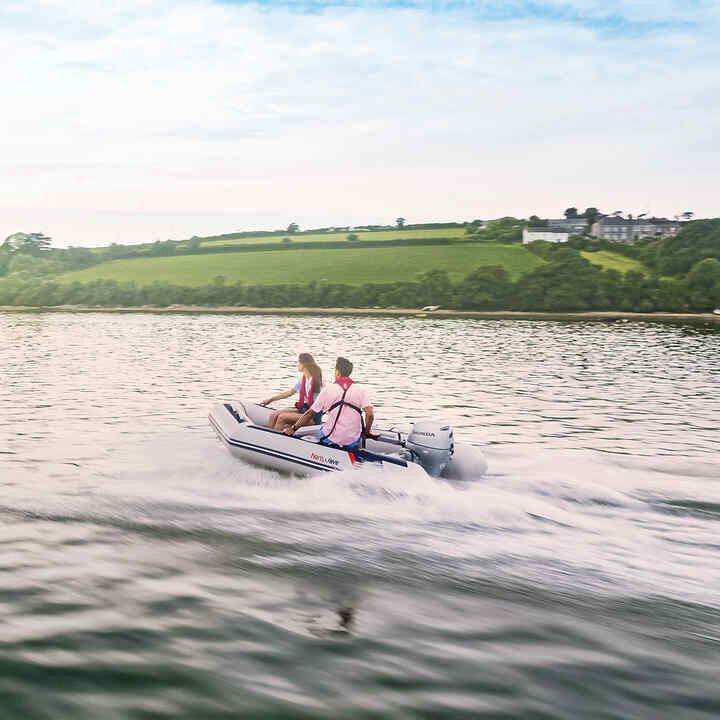 Couple on Honwave boat in lake location using Honda BF engine. 