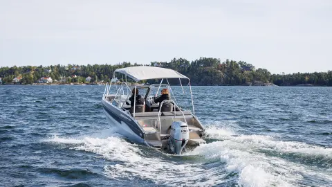 Models driving a boat with the BF80-100 engine in a sea location.