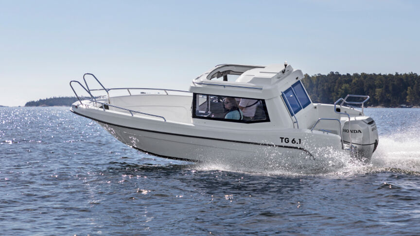 Model steering a boat in a sea location with the BF80-100 engine.