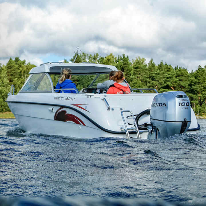 Family on a boat in lake location using Honda BF80-100 engine. 