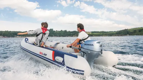 Close up of two people on boat in open water