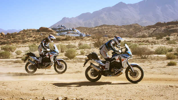 Two HAR riders in Morocco with the painted rocks in background